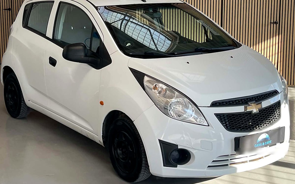 Hvid Chevrolet Spark set skråt forfra, hos Cars & Care i Slagelse