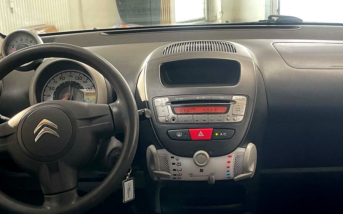Instrumentbrættet i den sølvfarvede Citroën C1 med radio og aircondition