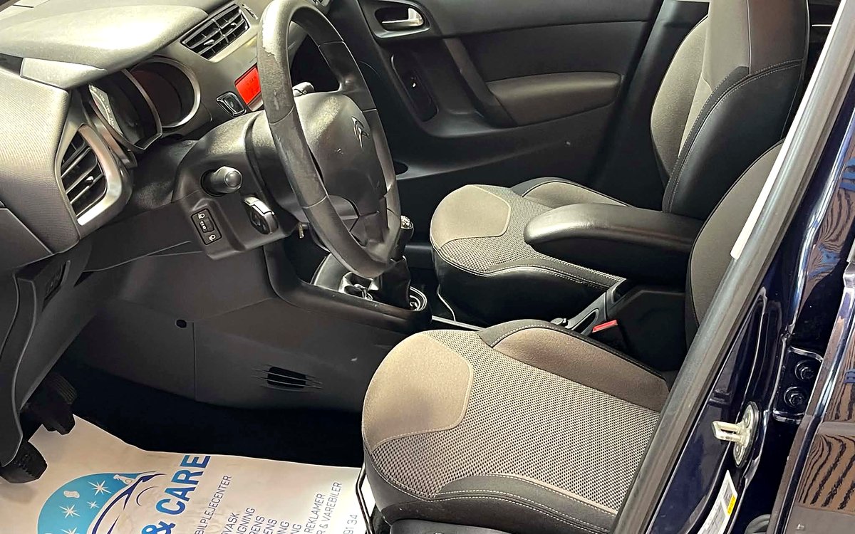 Førerpladsen i den mørkeblå Citroën C3 med stofsæder og armlæn