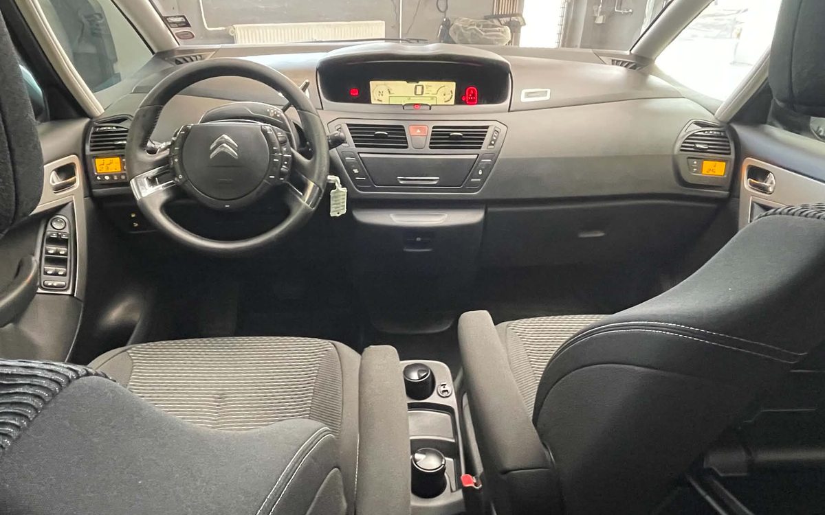Instrumentbrættet i den sorte Citroën C4 Grand Picasso med rat, digitalt instrument og forsæder