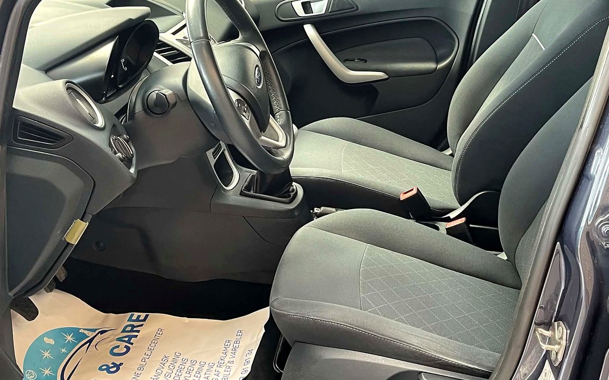 Førerpladsen i den grå Ford Fiesta med stofsæder