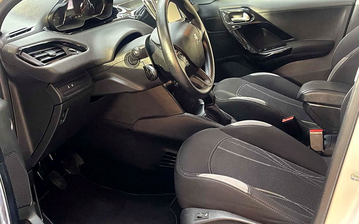 Førerpladsen i den hvide Peugeot 208 med rat og stofsæder