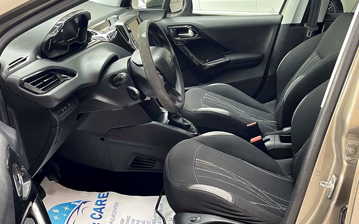 Førerpladsen i den beige Peugeot 208 med stofsæder