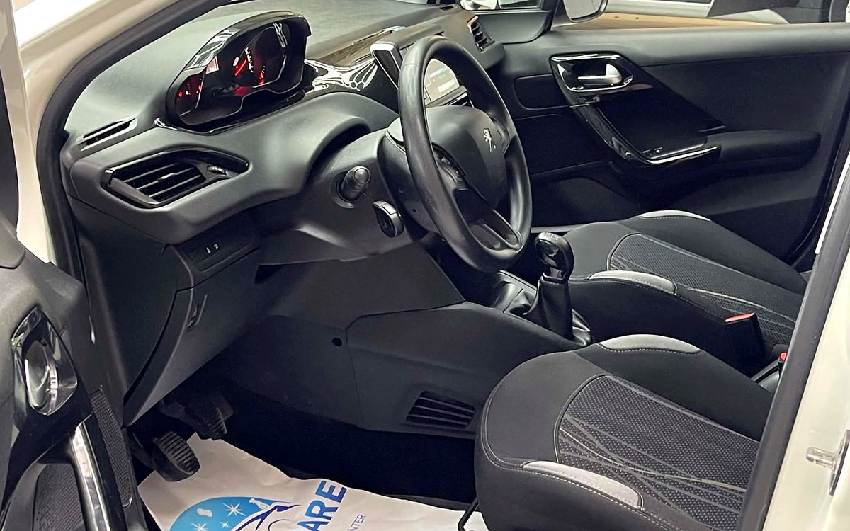 Førerpladsen i den hvide Peugeot 208 med stofsæder