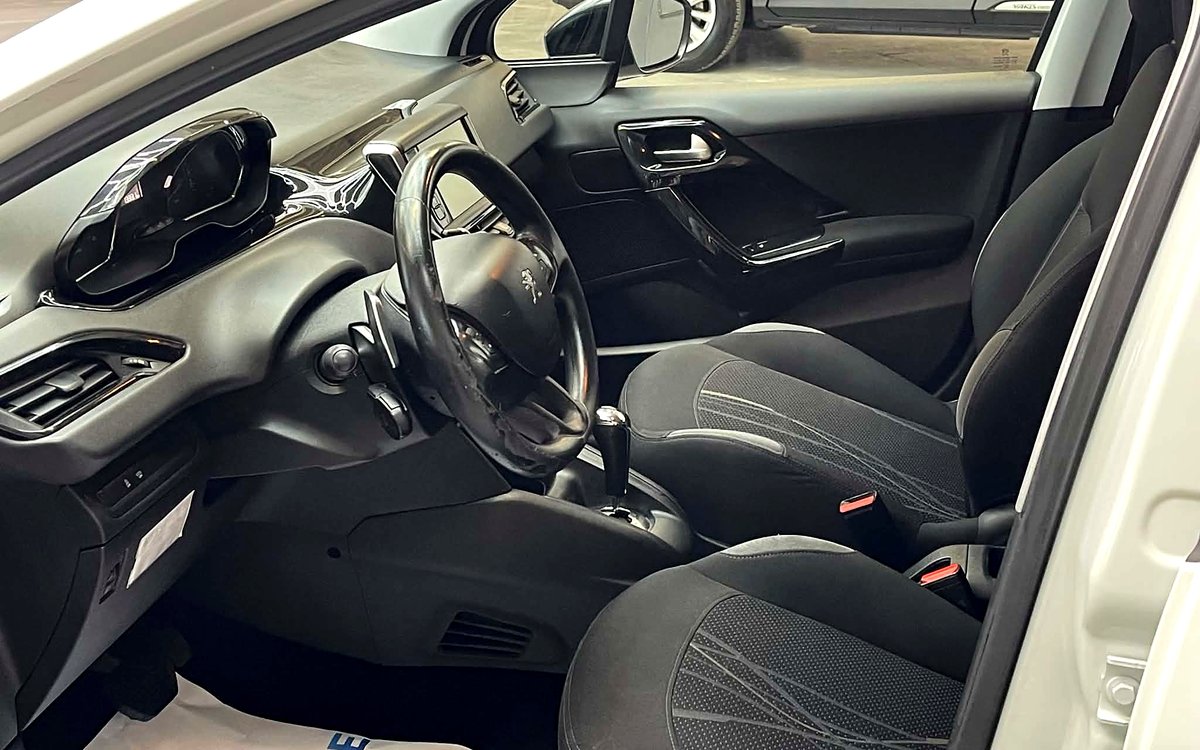 Førerpladsen i den hvide Peugeot 208 med stofsæder