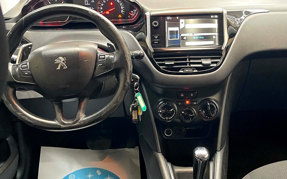 Instrumentbrættet i den hvide Peugeot 208 med rat, skærm og automatgear