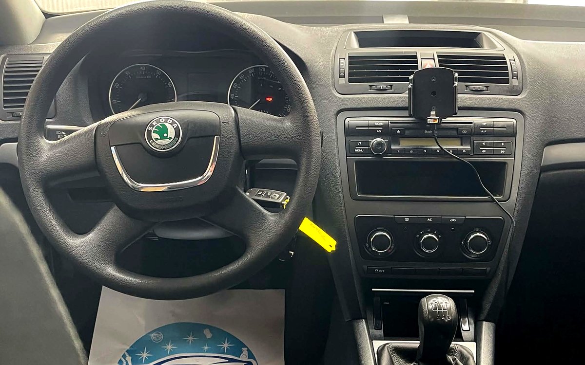 Instrumentbrættet i den beige Škoda Octavia med rat, radio og manuelt gear