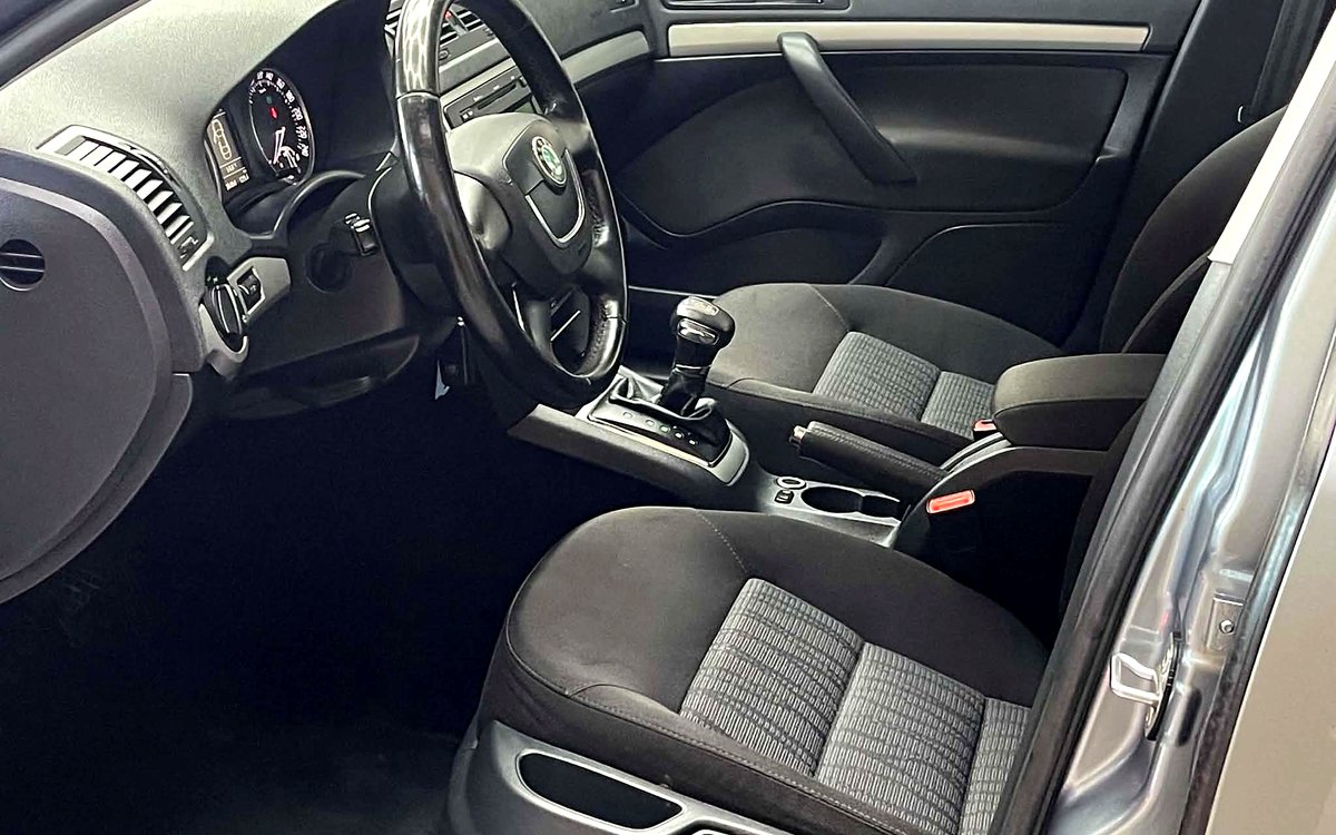 Førerpladsen i den grå Škoda Octavia med rat, instrumenter og automatgear