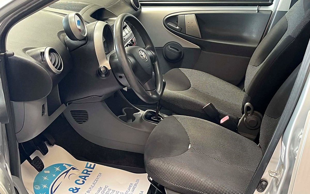 Førerpladsen i den sølvgrå Toyota Aygo med stofsæder