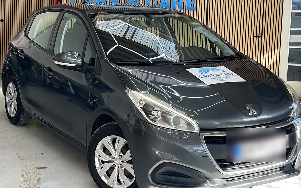 Mørkegrå Peugeot 208 set skråt forfra, hos Cars & Care i Slagelse